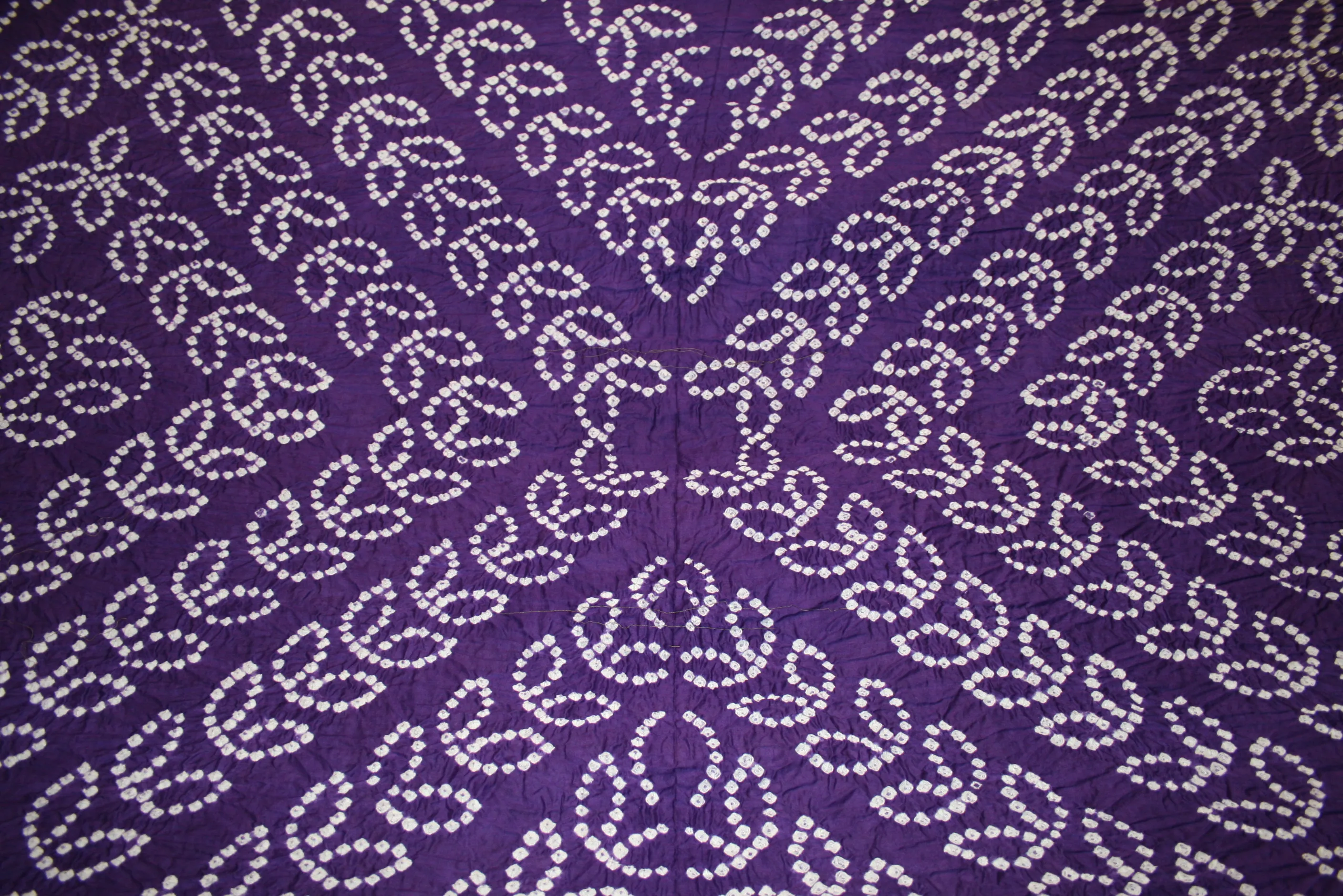 Tied Bandhani fabric being dipped in dye baths in Kutch Gujarat